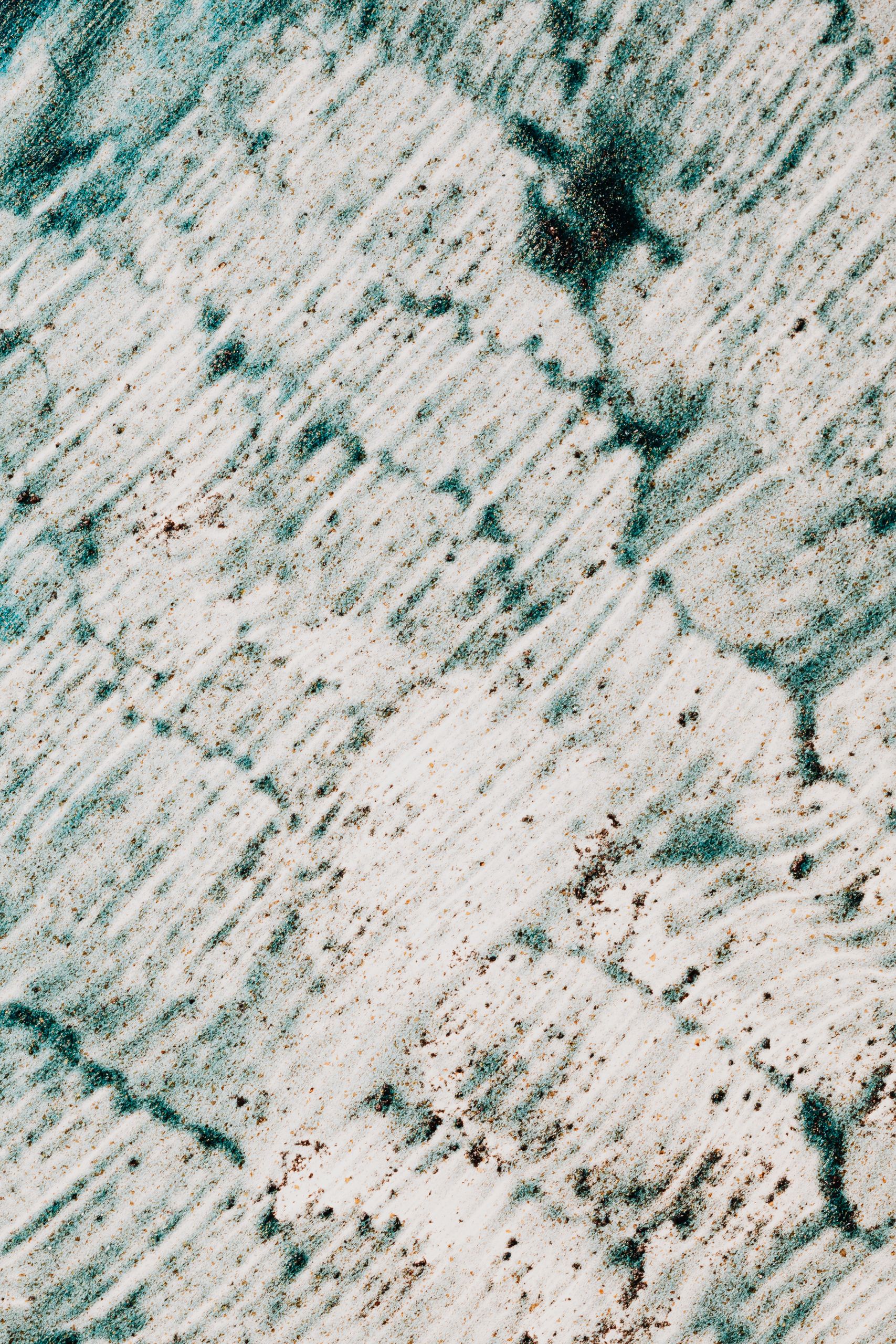 Abstract textured surface covered with green and brown color painted on white background